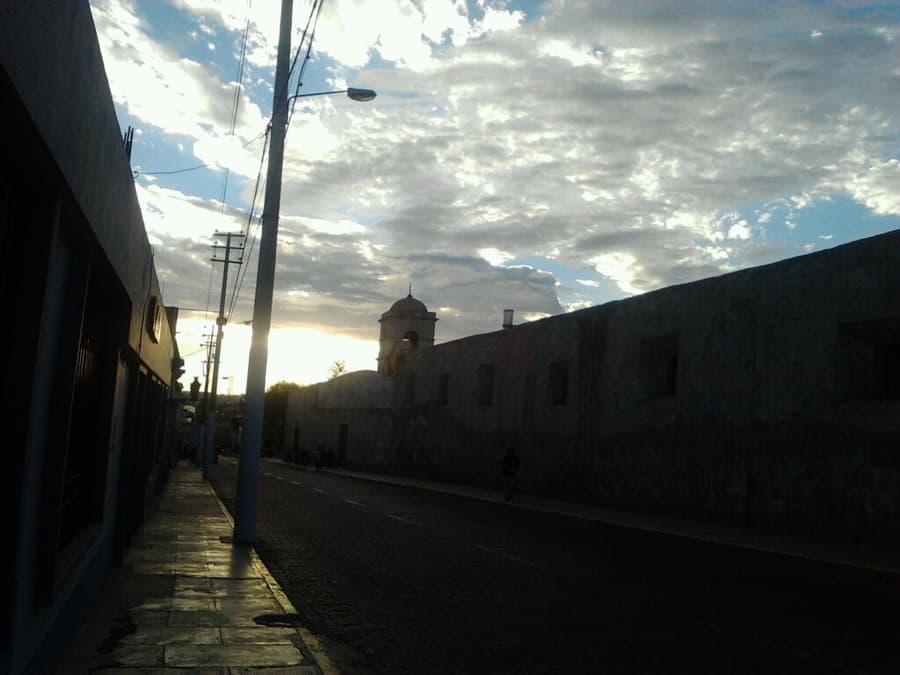 Atmospheric street at dusk with church silhouette, San Lázaro Arequipa